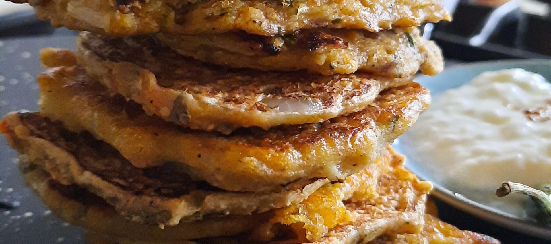 a stack of mini oat panckaes on top of a chapatti makeing pan a tawa